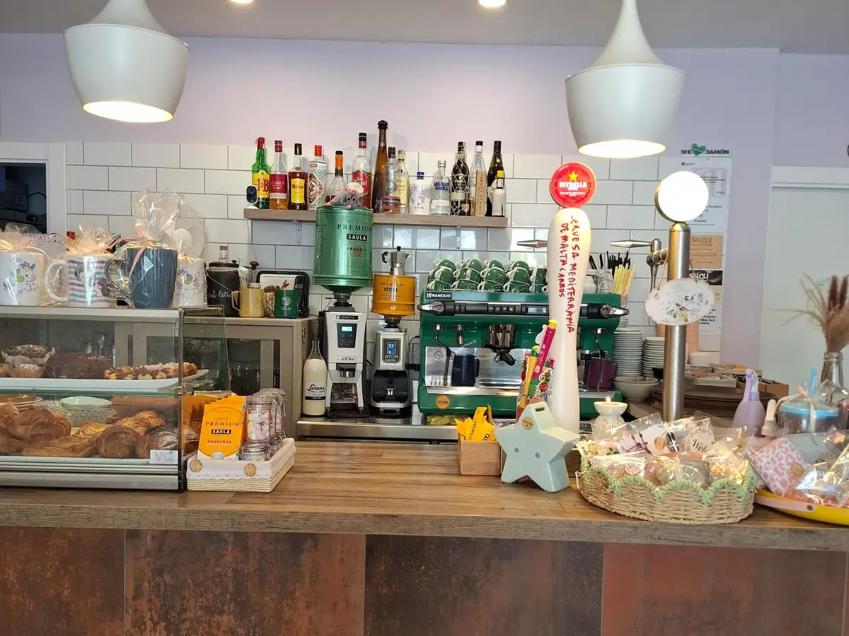 Barra de Cafetería Huma con cafetera profesional y exposición de productos en Salou